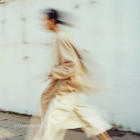 Stylish Woman in Motion Wearing Elegant Beige Outfit