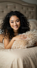 Smiling woman relaxing on bed with fluffy pillow