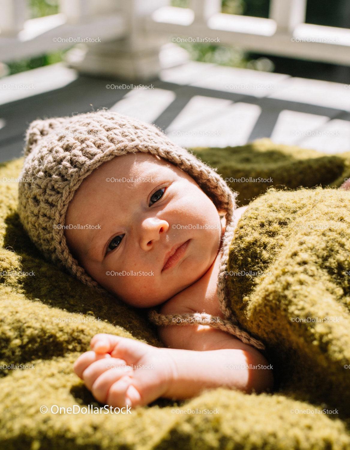 Newborn baby resting wrapped in cozy knitted blanket