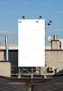 Blank vertical billboard on urban rooftop under blue sky