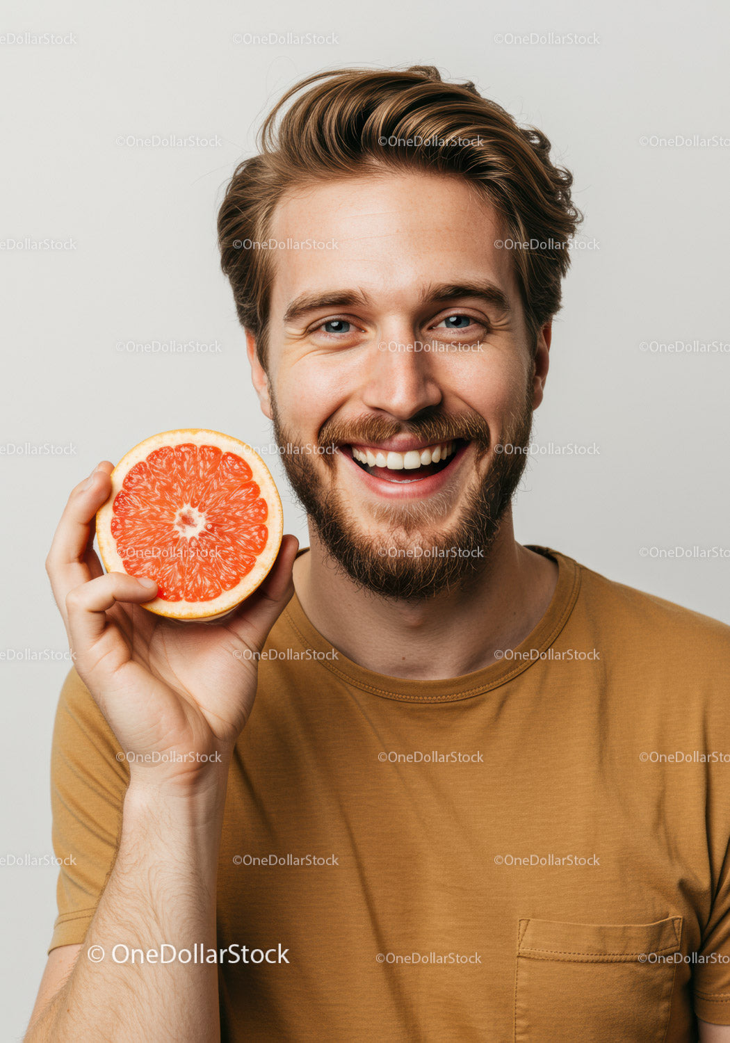 Happy Young Man with Bright Smile Holding Juicy Grapefruit Slice