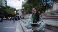 Young Woman Smiling Sitting on Steps with Tablet in City Park