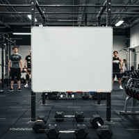 Empty whiteboard in gym with dumbbells and athletes