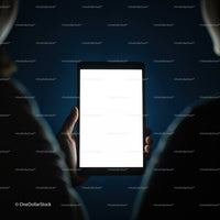 Person holding a tablet with glowing blank screen at night