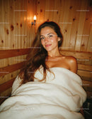 Beautiful Woman Relaxing in Cozy Wooden Sauna for Wellness and Spa