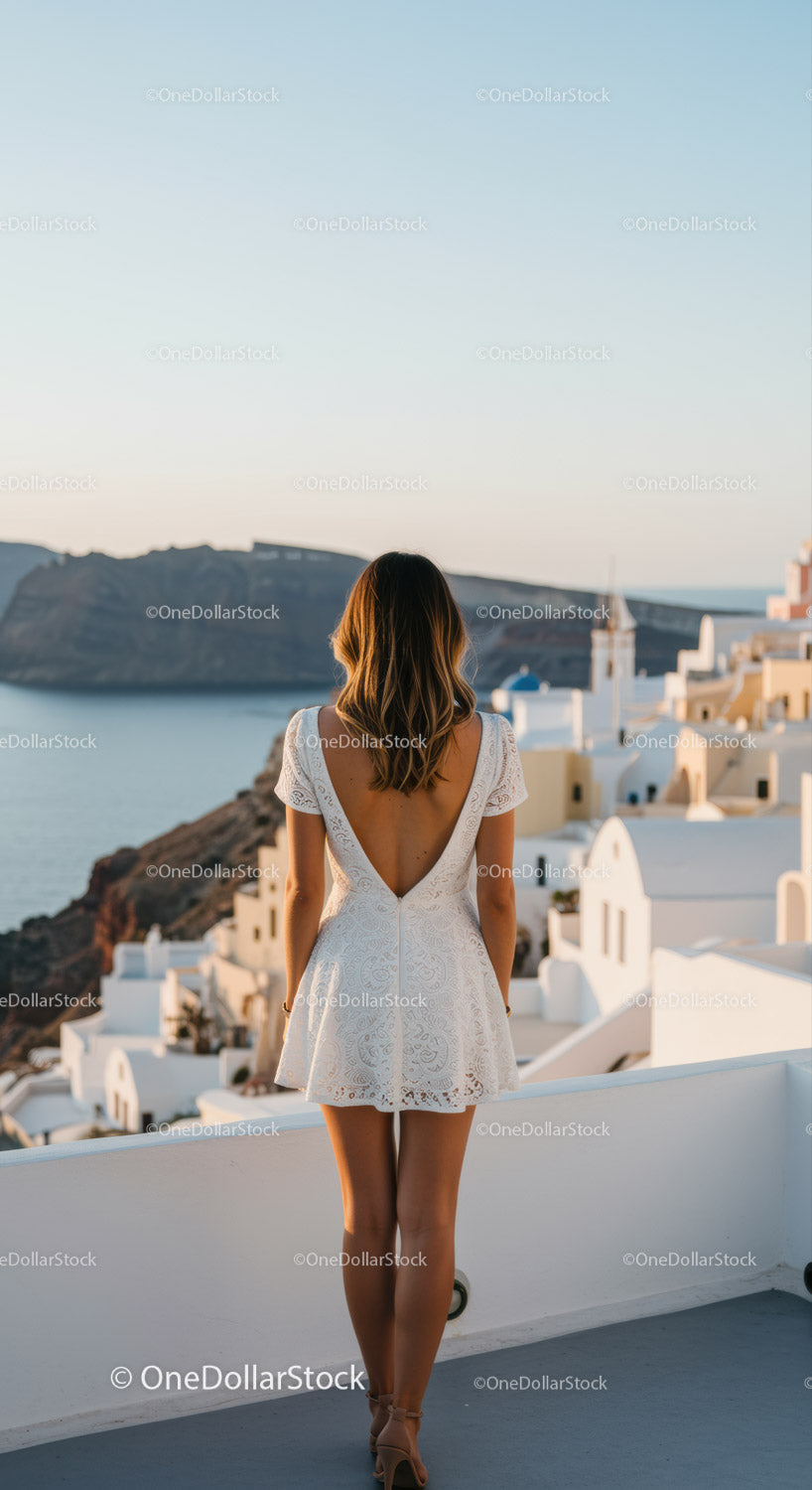 Kobieta w białej sukni z widokiem na kalderę Santorini
