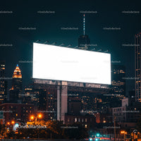 Large Illuminated Billboard Towering Over Cityscape at Night