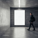 Young man walking past large blank display in modern space