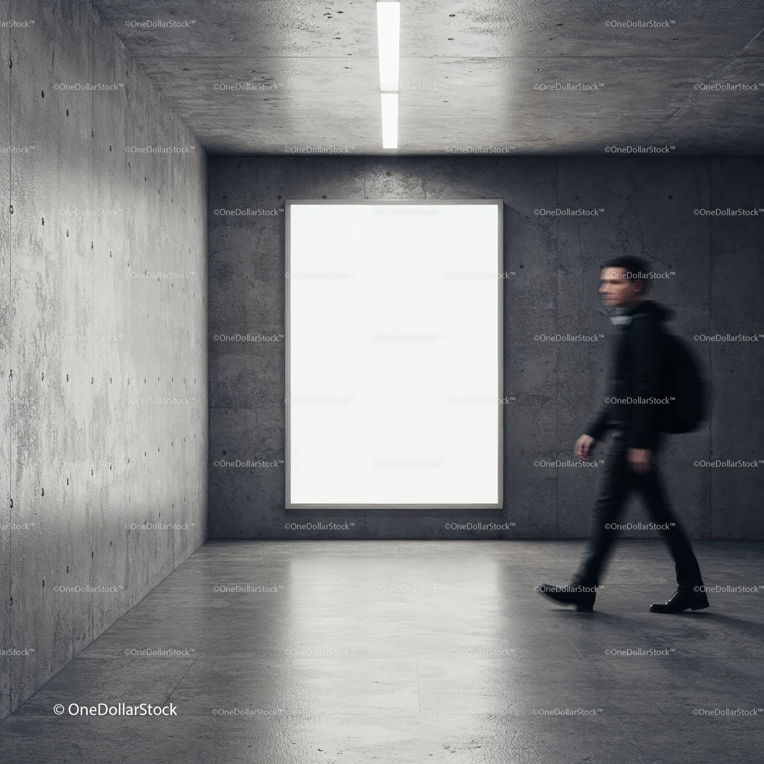 Young man walking past large blank display in modern space