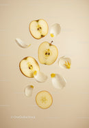 Fresh apple slices with scattered white flower petals