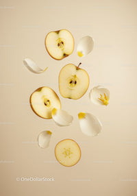 Fresh apple slices with scattered white flower petals