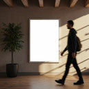 Man walking past blank poster in modern interior