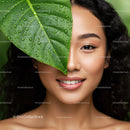 Smiling Woman with Tropical Green Leaves and Natural Skin