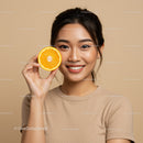 Vibrant Young Woman Holding Fresh Orange Slice in Studio