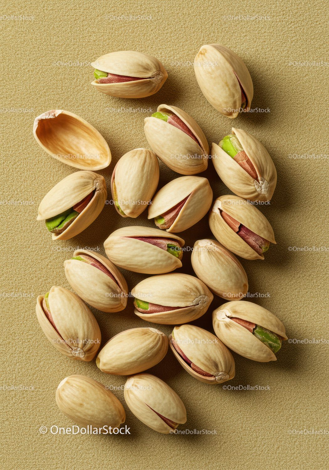 Close up of shelled pistachio nuts on textured surface