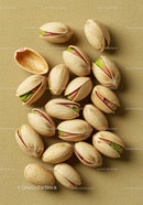 Close up of shelled pistachio nuts on textured surface
