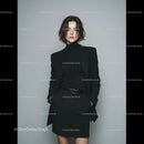 Elegant Woman in Black Suit Posing Confidently in Modern Studio