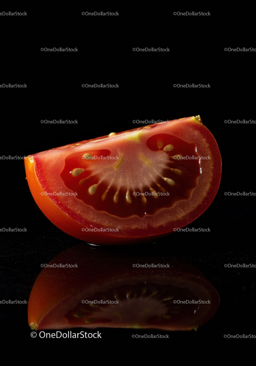 Fresh tomato slice with seeds on dark reflective surface