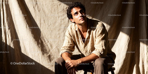 Thoughtful young man sitting in warm natural light