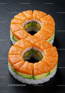 Ring-shaped salmon and avocado sushi on black slate