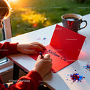 Child Writing Love Message on Red Valentine Card