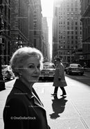 Elderly Woman in Busy City Street Surrounded by Vintage Cars