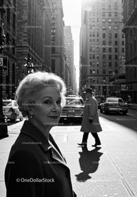 Elderly Woman in Busy City Street Surrounded by Vintage Cars