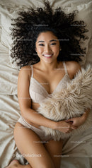 Smiling woman lying on bed with soft pillow embrace
