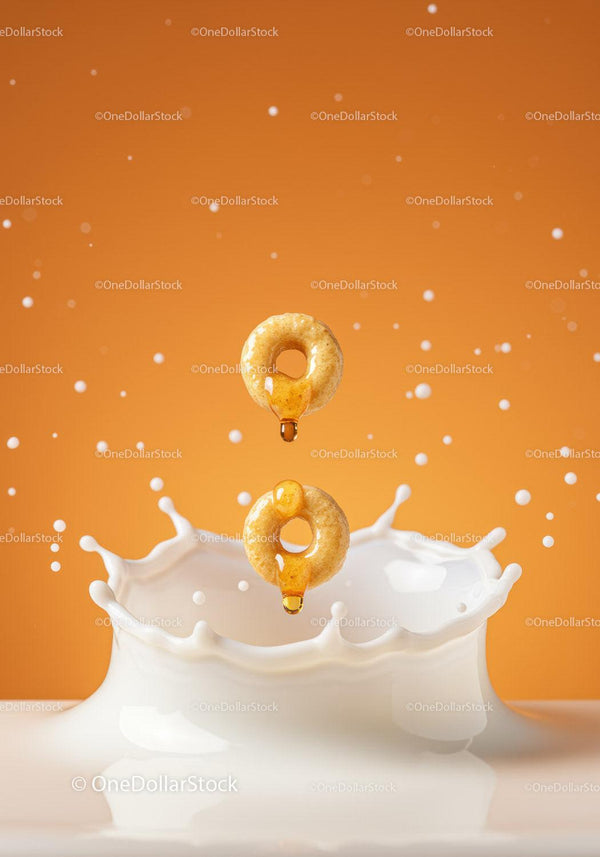 Honey Drizzled Cereal Rings Splashing into Milk