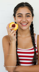 Young Girl Smiling Holding Peach in Bright Casual Setting