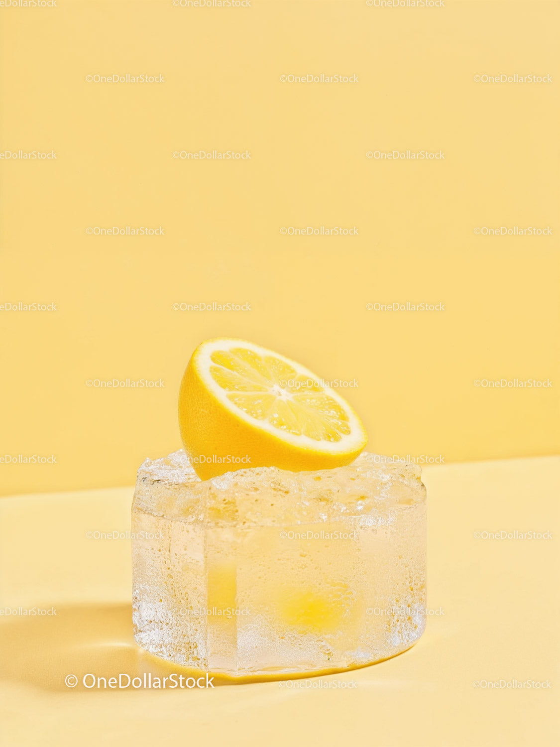 Fresh lemon half resting on large melting ice cube