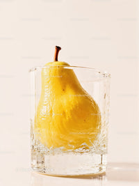 Fresh yellow pear immersed in clear glass of water