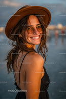Smiling Woman in a Hat with Sunglasses at the Beach During Sunset