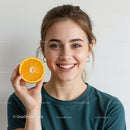 Cheerful Woman Holding Fresh Orange Slice with Bright Smile