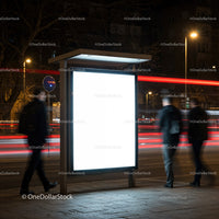 Illuminated urban bus stop with blurred pedestrians at night