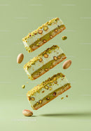 Pistachio layered dessert bars with nuts on green background