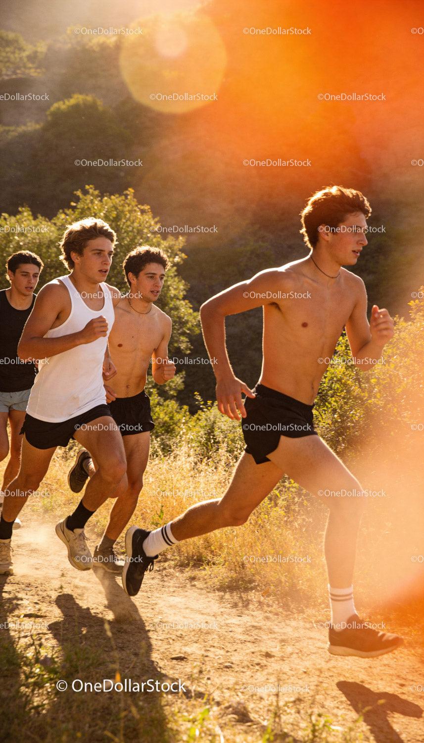 Young men running trail in warm golden sunlight