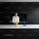 Woman preparing lemon in modern minimalist kitchen