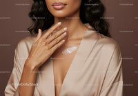 Elegant Woman Applying Body Lotion with Smooth Skin and Silky Robe