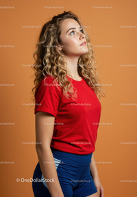 Young woman in red shirt looking upward thoughtfully