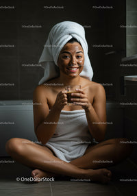Woman with Facial Mask and Towel Wrap Relaxing in Bathroom