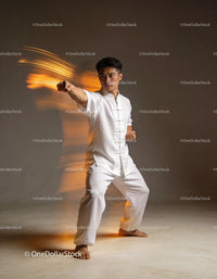 Martial artist performing powerful punch in white uniform