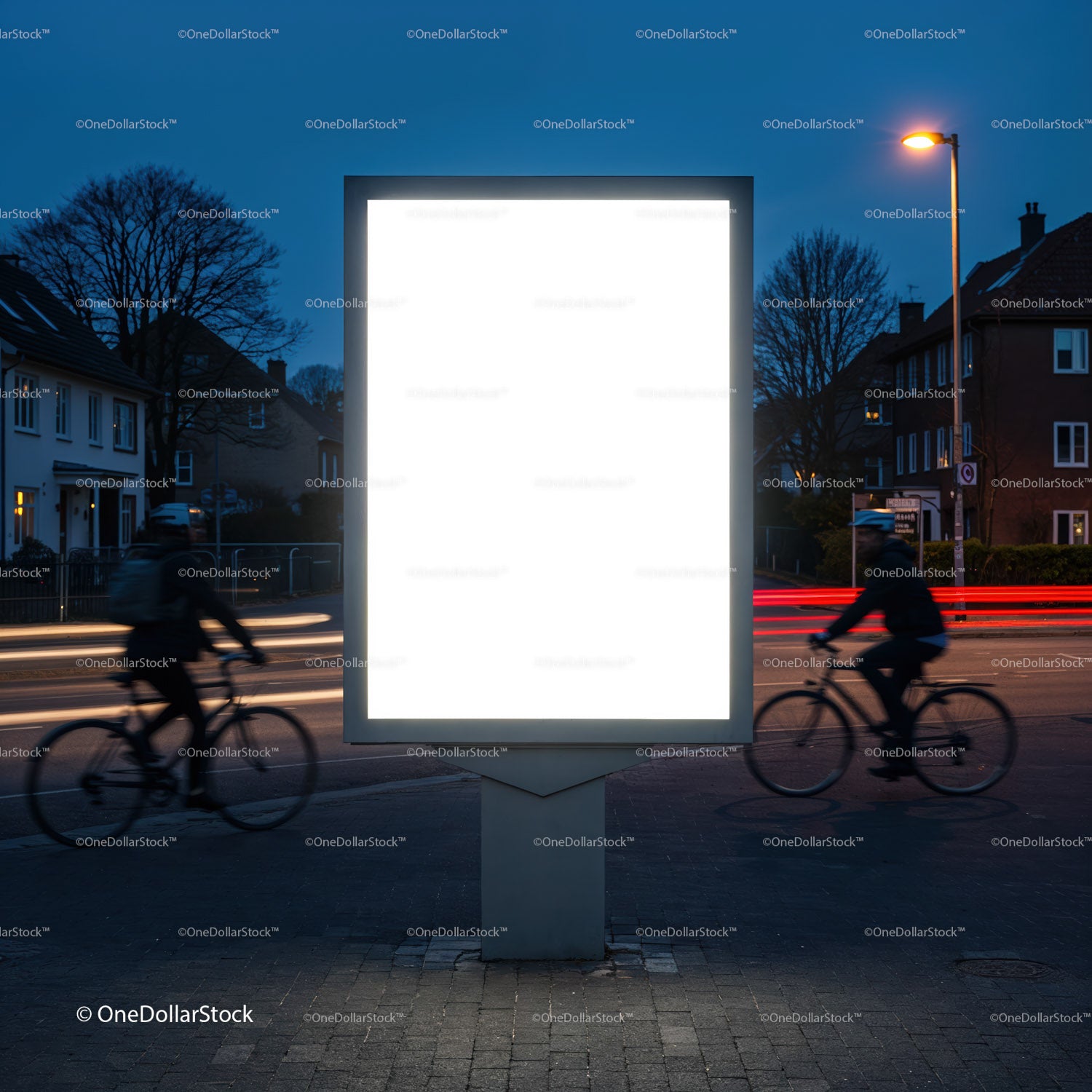 Urban illuminated billboard with motion blurred cyclists at dusk