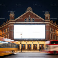 Historic theater facade with large blank billboard at night