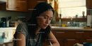 Thoughtful woman writing in warm sunlit kitchen