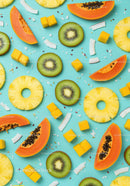 Tropical summer fruits slices arranged on blue background