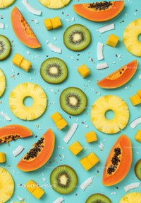 Tropical summer fruits slices arranged on blue background