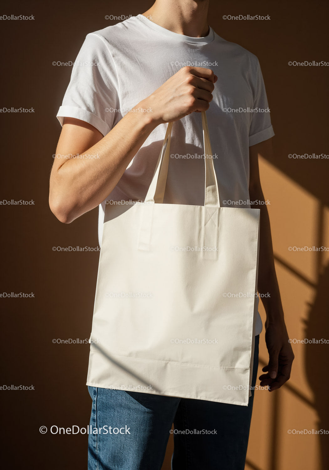 Casual man holding blank beige tote bag in warm light