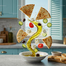 Mediterranean ingredients swirling over olive oil bowl