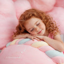 Smiling redhead girl resting on pastel marshmallow pillow